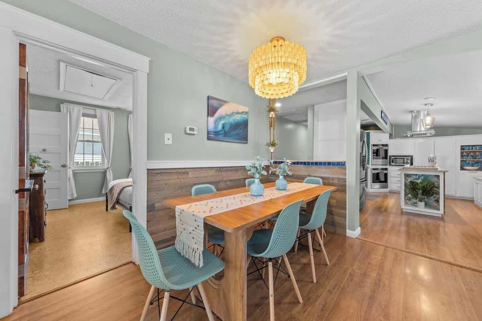 Dining area w/ long table & warm lighting, perfect for shared meals & conversation