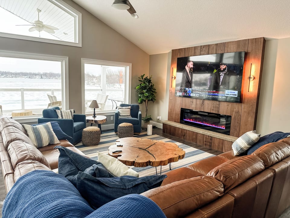 Lake Life's great room has it all- expansive living space with cozy fireplace and smart tv.  Covered outdoor living and dining space is just steps away!