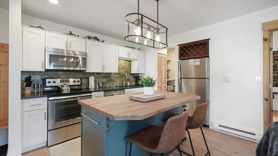 Fully equipped kitchen with stainless steel appliances and elegant island seating. Cook, gather, and enjoy.