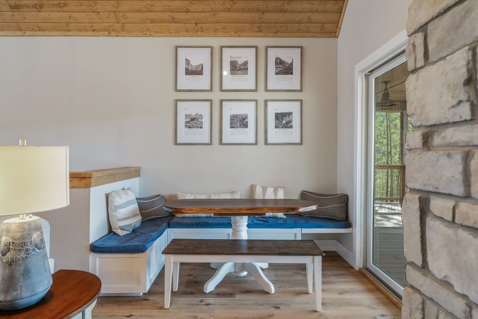Settle into your cozy breakfast nook with soft blue cushions and rustic charm, perfect for morning coffee while gazing out at nature.