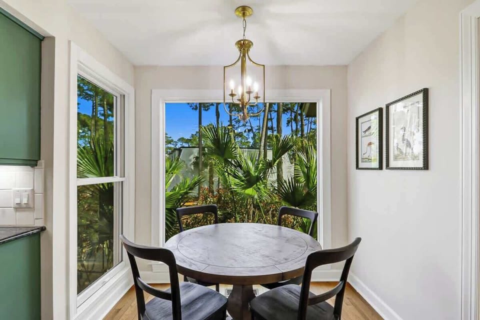 Enjoy intimate meals at your elegant round table, surrounded by tropical garden views through floor-to-ceiling windows that fill the space with natural light.