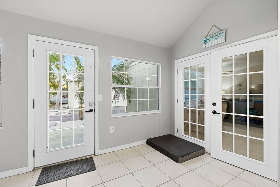 This beach stay entry features French doors, patio access, and natural light—creating a welcoming space with easy indoor-outdoor flow after a relaxing day at the beach.