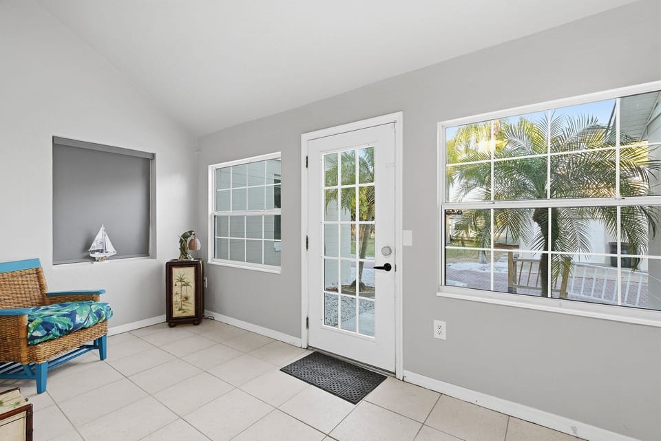Bright beach stay entryway with seating, large windows, and direct patio access—perfect for enjoying natural light and easy indoor-outdoor flow after a relaxing day at the beach.