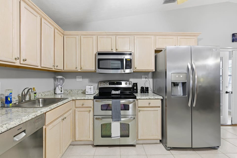 This beach stay kitchen features stainless steel appliances, spacious countertops, and plenty of storage—ideal for cooking and gathering after a fun day by the beach.