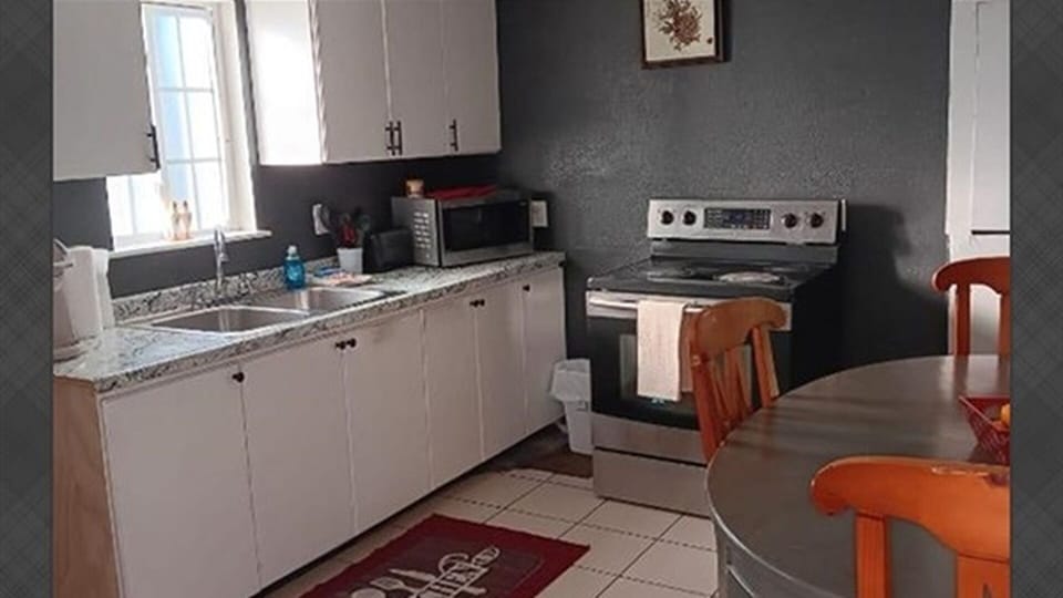 Kitchen and dining area with stove, microwave, and seating