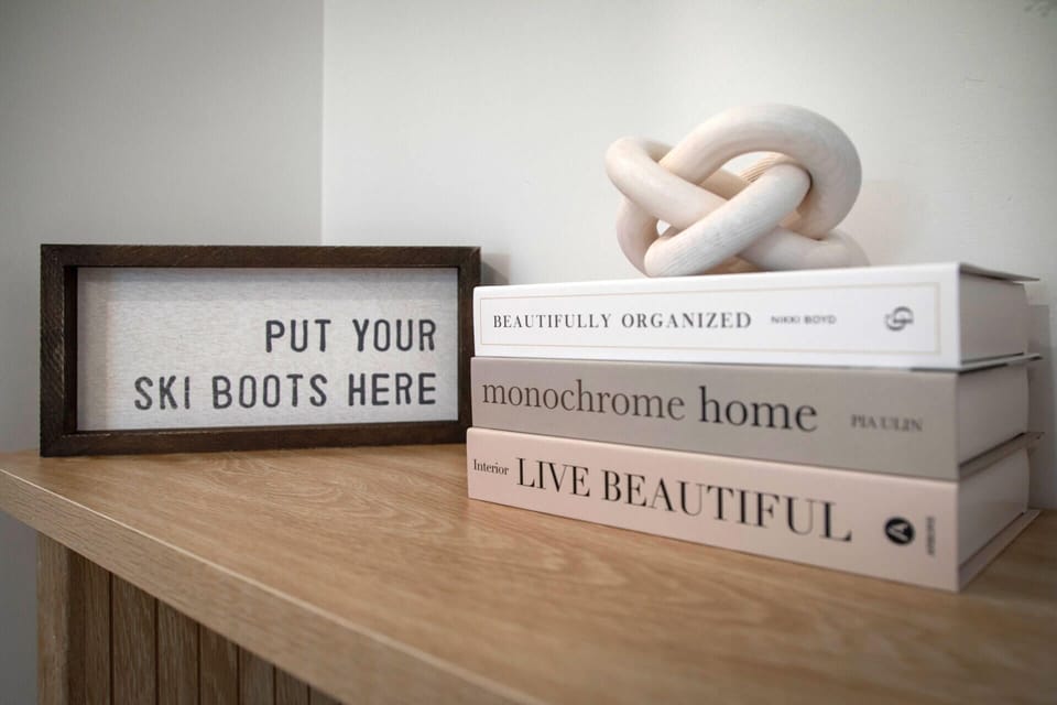 Thoughtful decor touches make your space feel like home, with ski-themed humor and stylish books creating a cozy atmosphere.