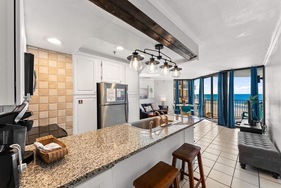 open kitchen with granite countertops and ocean views in the living area