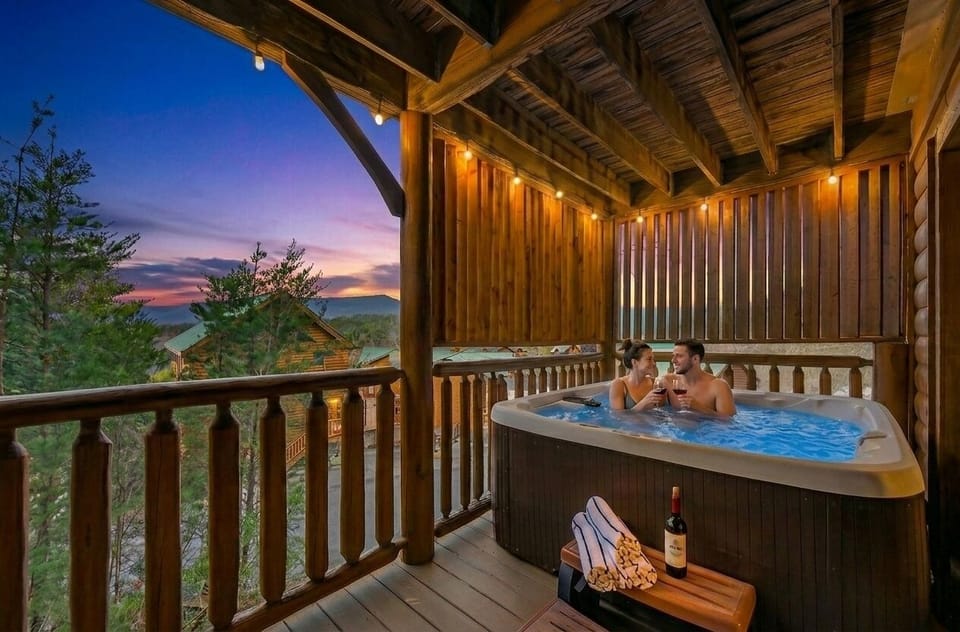 Your evening starts here — covered hot tub, Smoky Mountain sunset, and nowhere else you need to be. Pool towels provided for every guest.