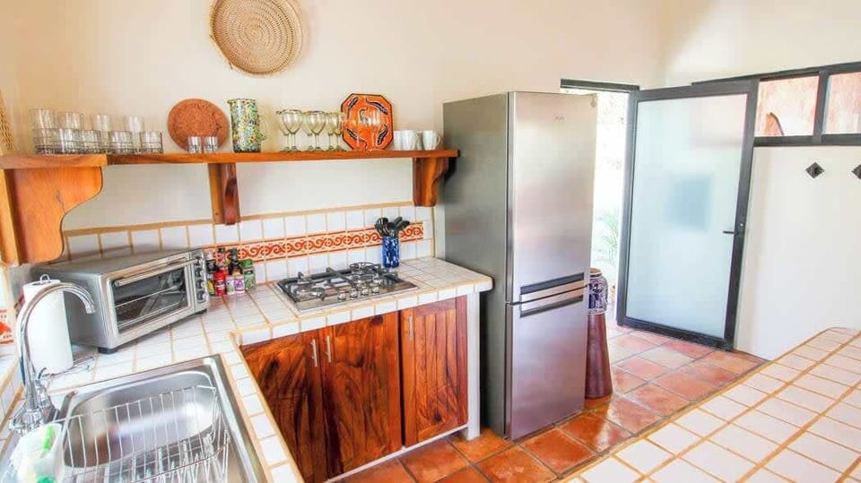 Kitchen with fridge, gas stovetop, toaster oven, coffee maker, dishes and all essentials. 