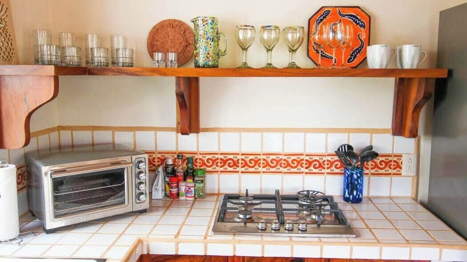 Kitchen with fridge, gas stovetop, toaster oven, coffee maker, dishes and all essentials. 