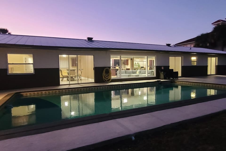 Evening glow at the retreat! The sunset sky reflects beautifully in the pool, mirrored by the wide windows and sliding doors. A perfect view of our indoor-outdoor lifestyle, where the house truly shines as day turns to night
