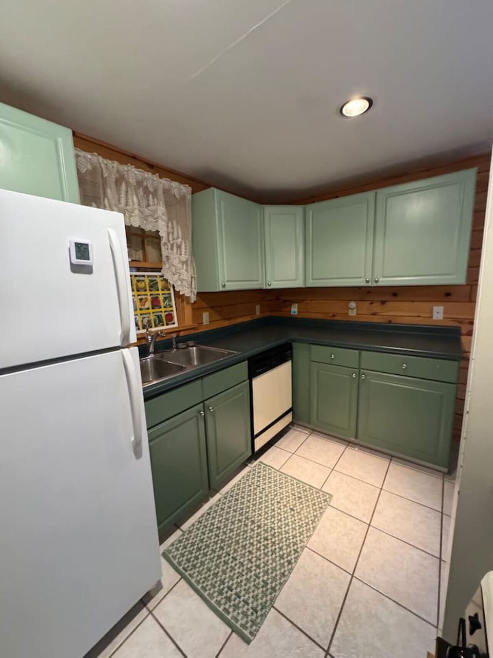 full kitchen with modern appliances, stone counters, and everything needed for easy meals. Open dining area with rustic cabin charm and views of towering pines, giving guests a true Adirondack experience on this private 30-acre retreat.