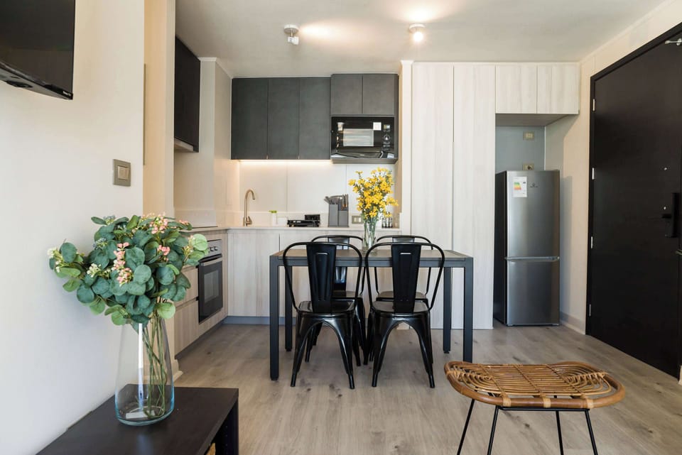 Modern kitchen with sleek appliances and a stylish dining area, perfect for enjoying a meal at home.