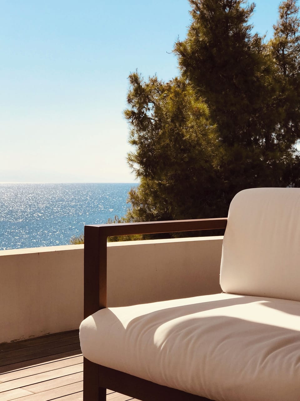 Outdoor lounge corner with sea views and filtered sunlight