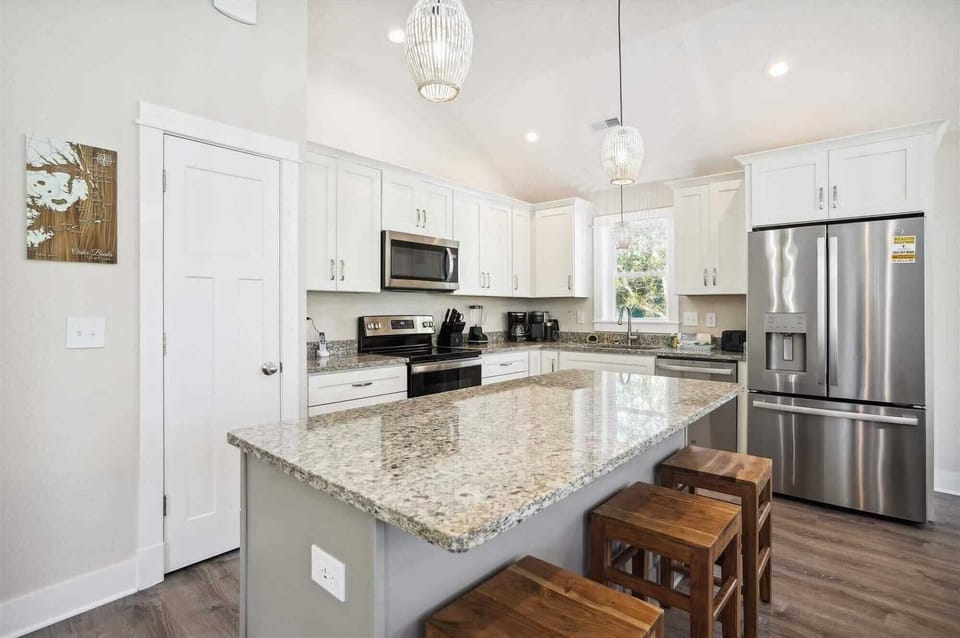 Fully equipped kitchen with granite top kitchen island and wooden seats