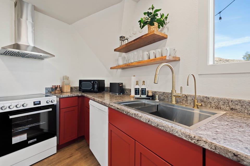 Fully stocked kitchen with spices, oil, cookware 