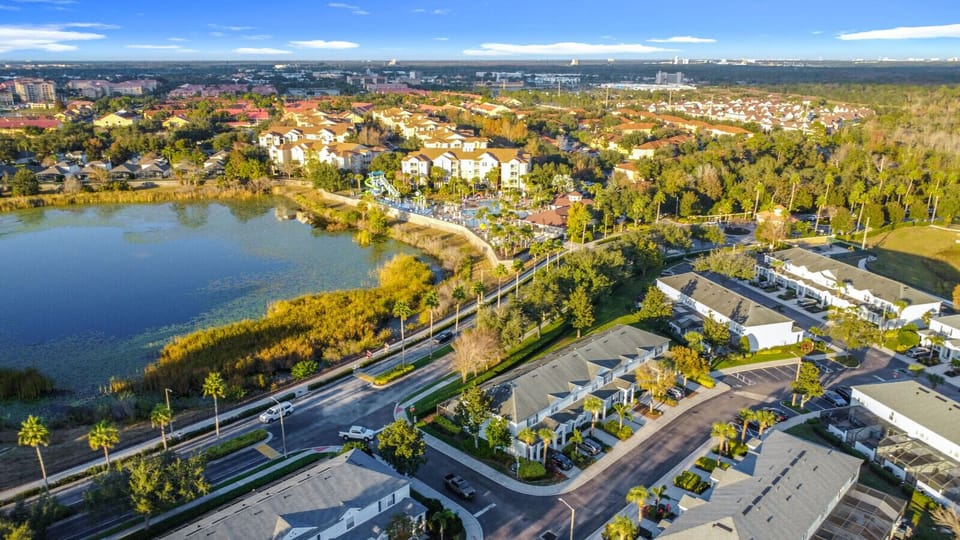 Aerial view of the peaceful neighborhood surrounded by lake and greenery.