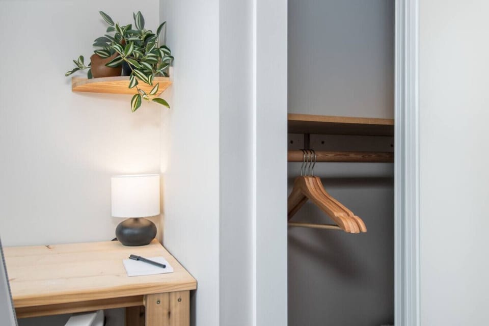 Spacious bedroom closet with wooden hangers for easy clothing storage.