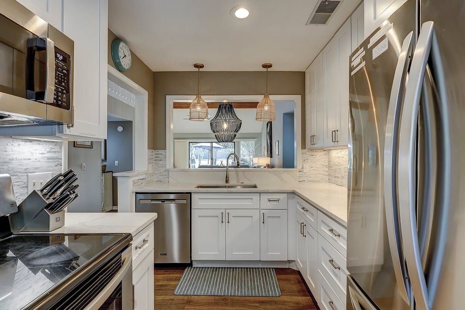 Fully stocked kitchen with stainless steel appliances.
