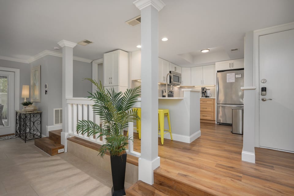 Fully stocked kitchen with stainless steel appliances and 2 barstools for extra seating.