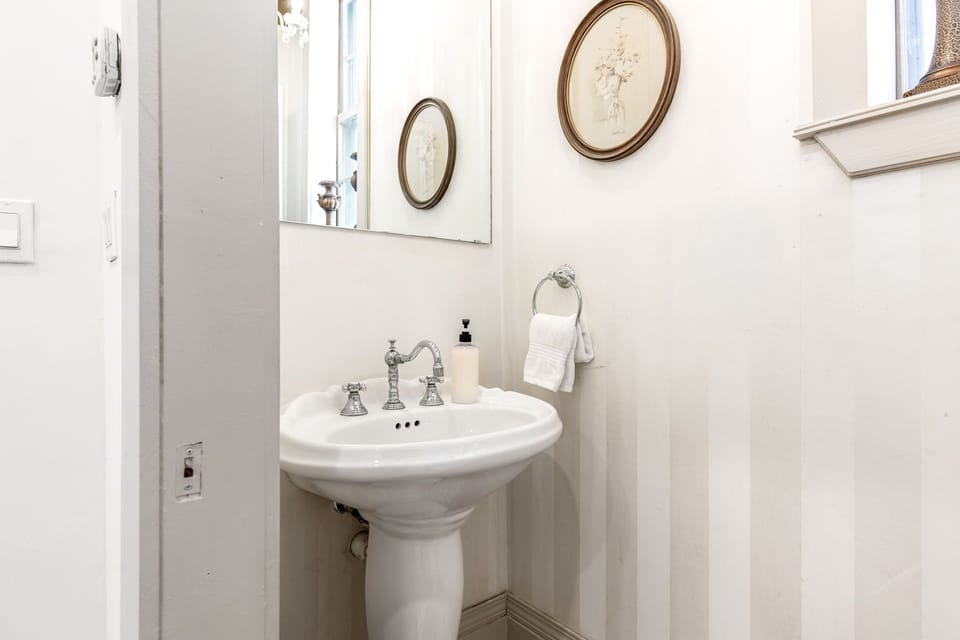 Half bathroom with a pedestal sink and toilet.