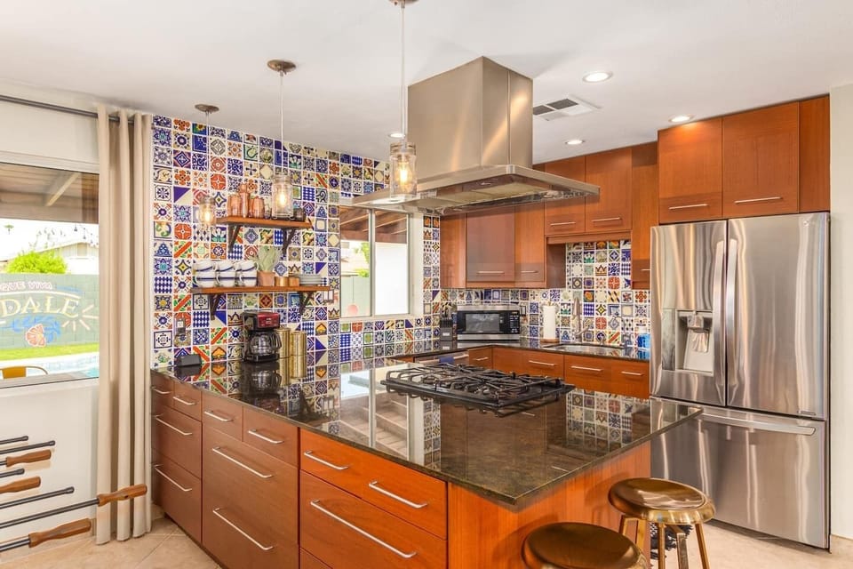 Fully equipped kitchen with granite island and colorful tile backsplash