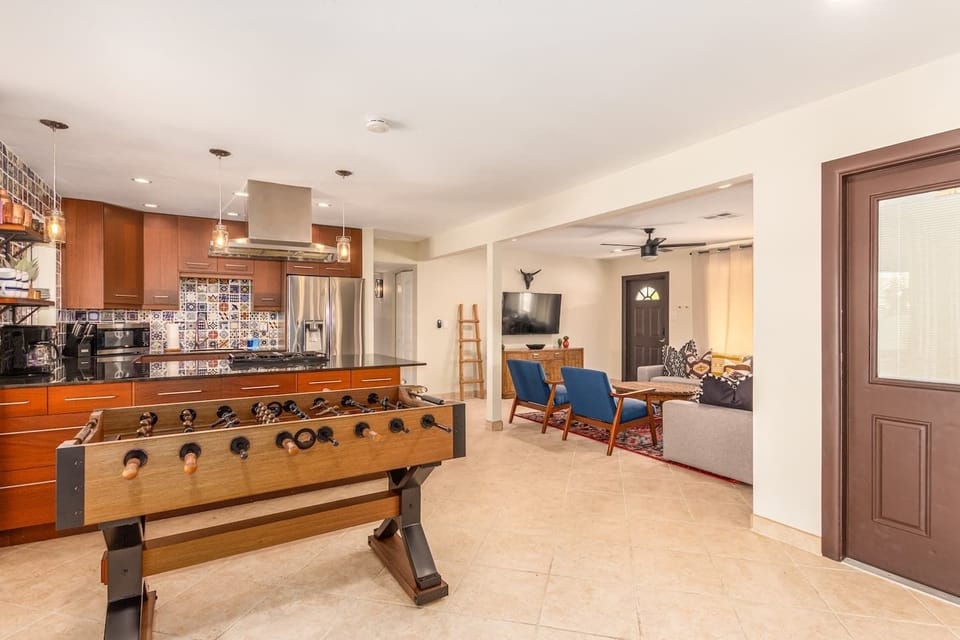 Open layout connecting living room, kitchen, and entertainment area