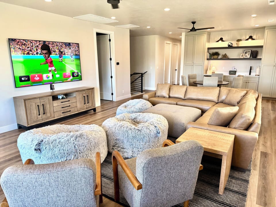 Leather sofa and ottoman, chairs, bean bags, 85” TV with movies and video games.