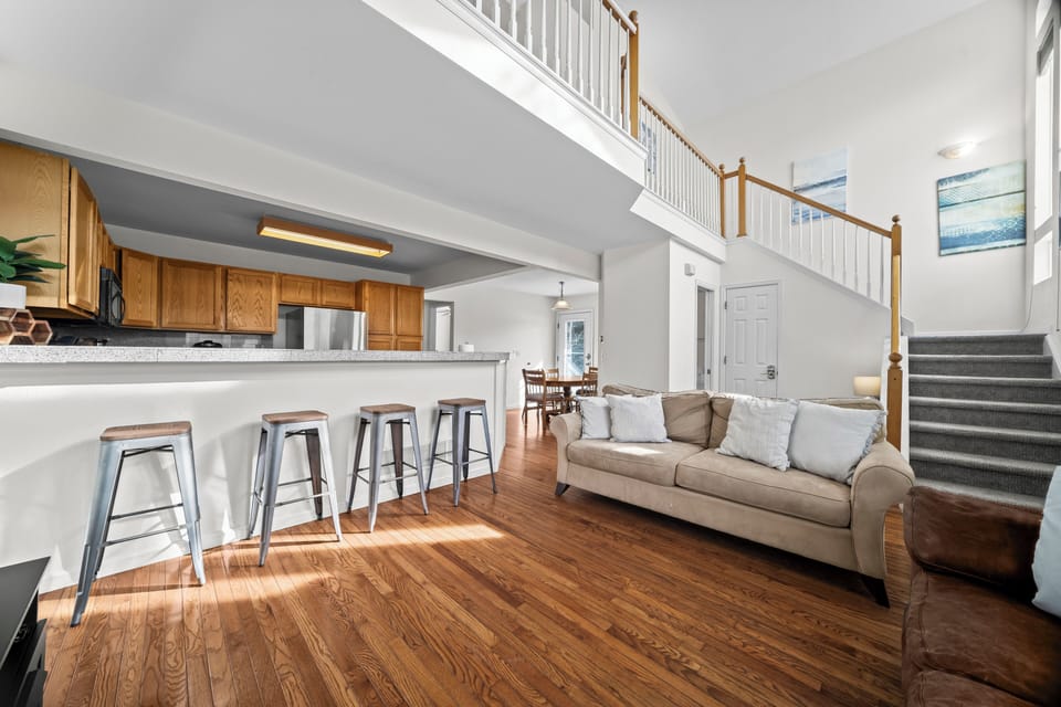 Bright living space with comfortable seating and open connection to kitchen bar