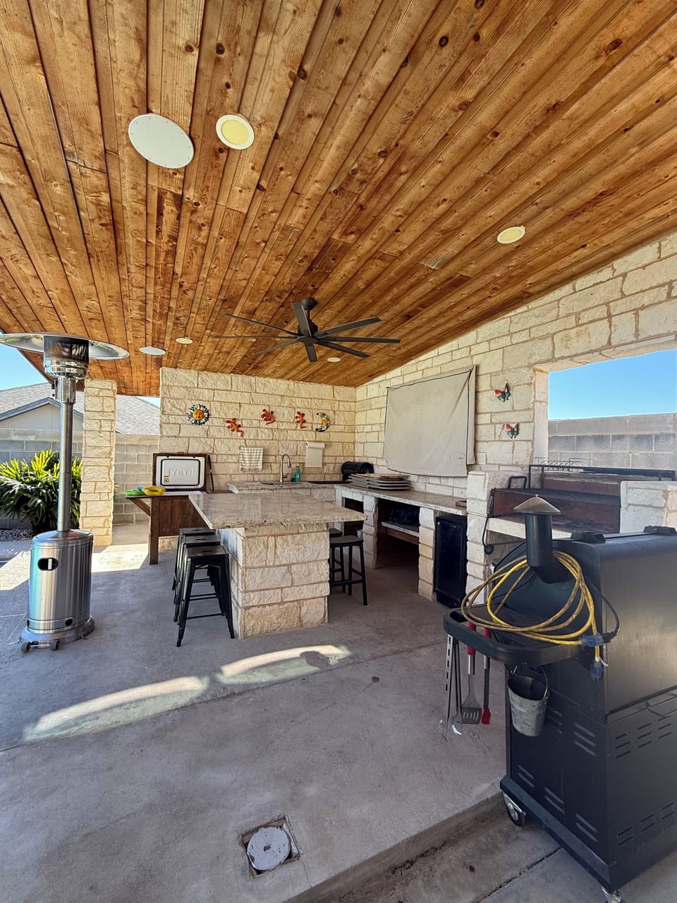 Outdoor mini  refrigerator, 65 inch TV, pellet smoker, fan and great lighting 