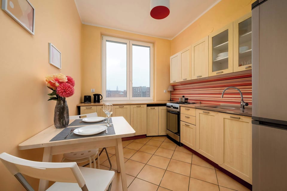 A dining nook in the kitchen with a small table and chairs. Light walls and tiled flooring give it a clean appearance. The area feels suitable for everyday meals.