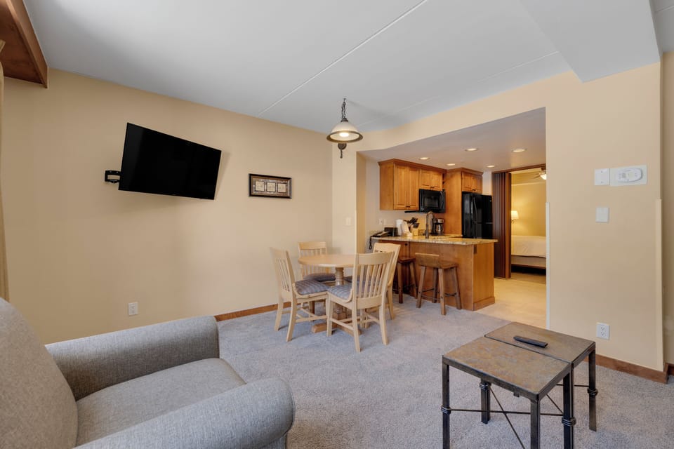 Relax in your open-plan living space with comfortable seating, dining table, and modern kitchen - perfect for preparing meals and unwinding together.