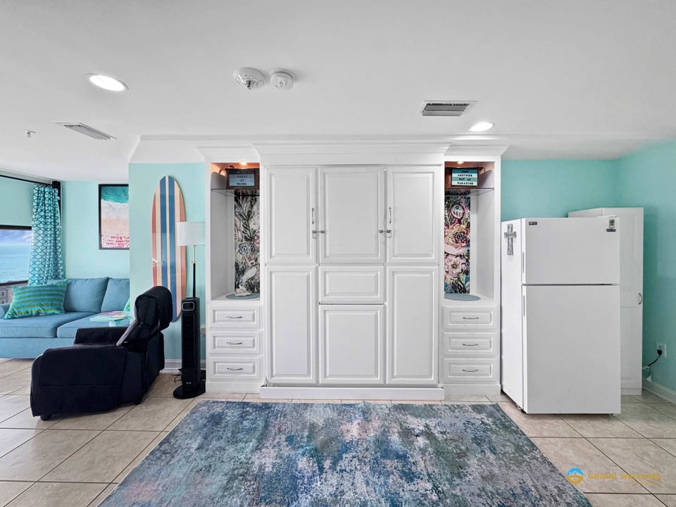 Cozy studio featuring a Murphy bed, dining tables, and kitchenette