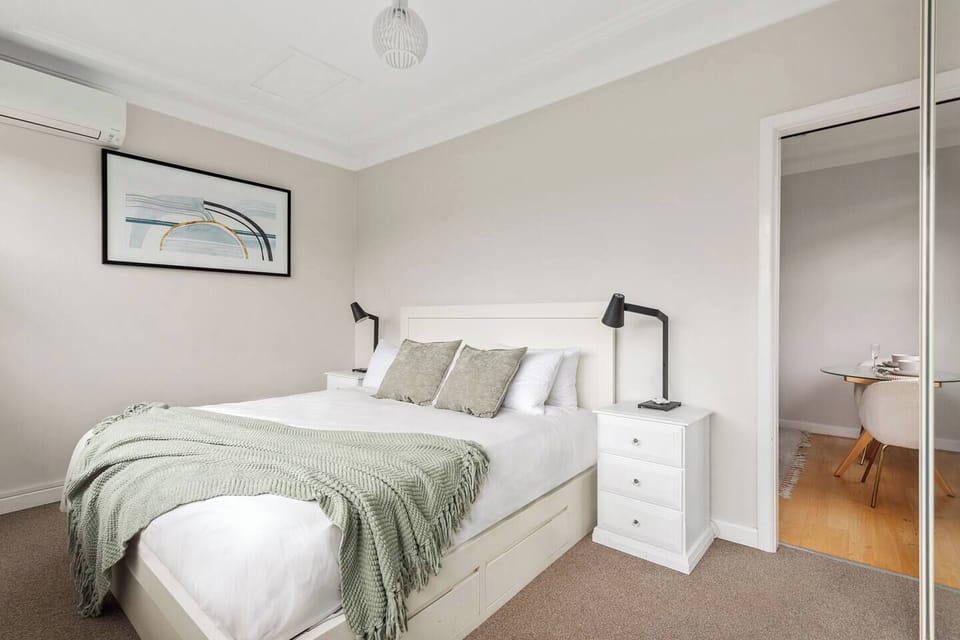 Peaceful bedroom retreat offers a king bed with quality linen, blackout blinds, a mirrored built-in wardrobe, split-system air conditioning and an elevated leafy outlook.