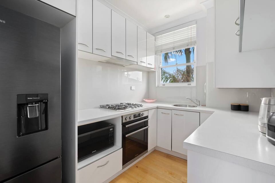 The kitchen supports effortless home cooking with modern appliances, such as an oven, microwave, fridge, dishwasher, and everyday essentials.