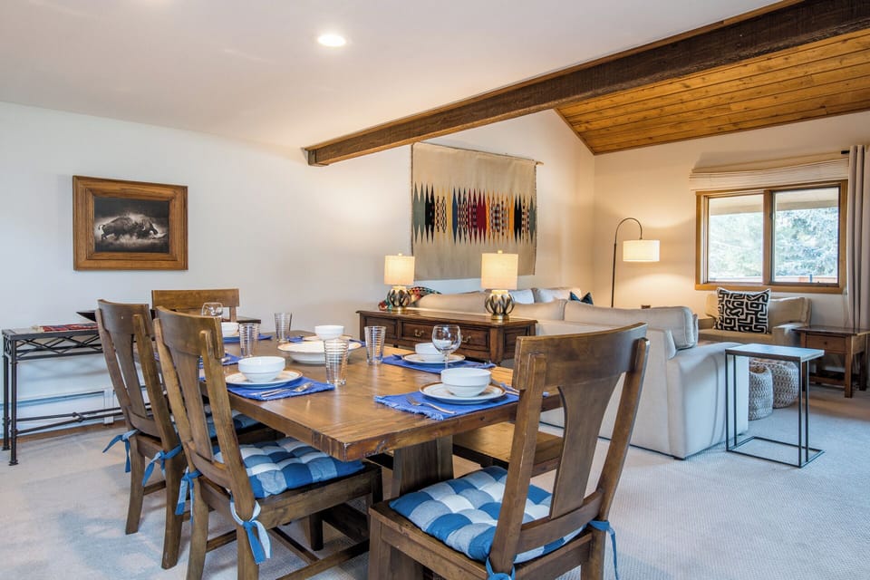 Gather around your beautifully set dining table where warm wood tones and soft lighting create the perfect atmosphere for memorable meals together.