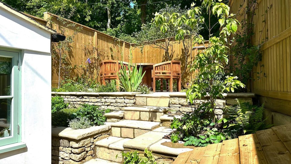 Planted borders and climbing roses frame the space where you can set the table for a feast.