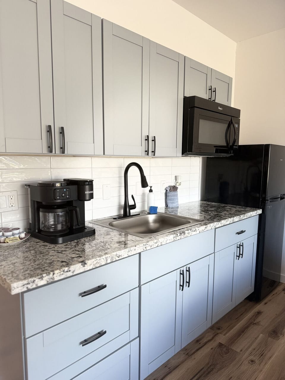 Kitchenette equipped with essential tools for preparing small meals. There is no stove or oven, but it includes a portable hot plate, skillet, and other basic cookware