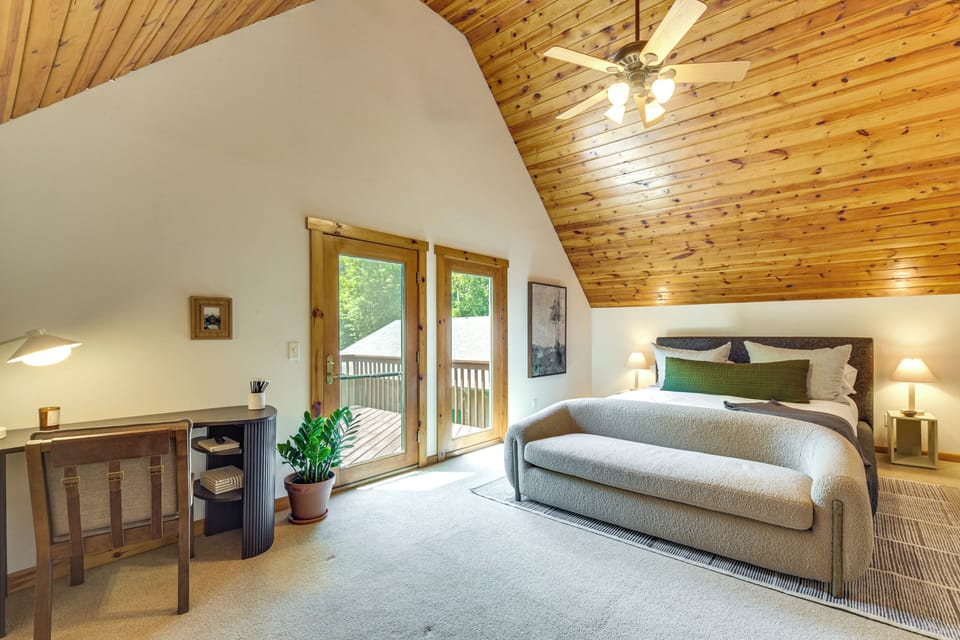 The primary suite upstairs is spacious and features a smart tv, desk, chair and a couch.