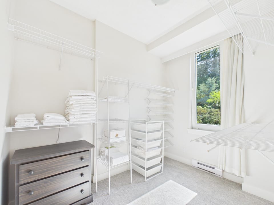 Spacious en-suite walk-in closet complete with white wire organizer shelving, drawers, and hanging rods.