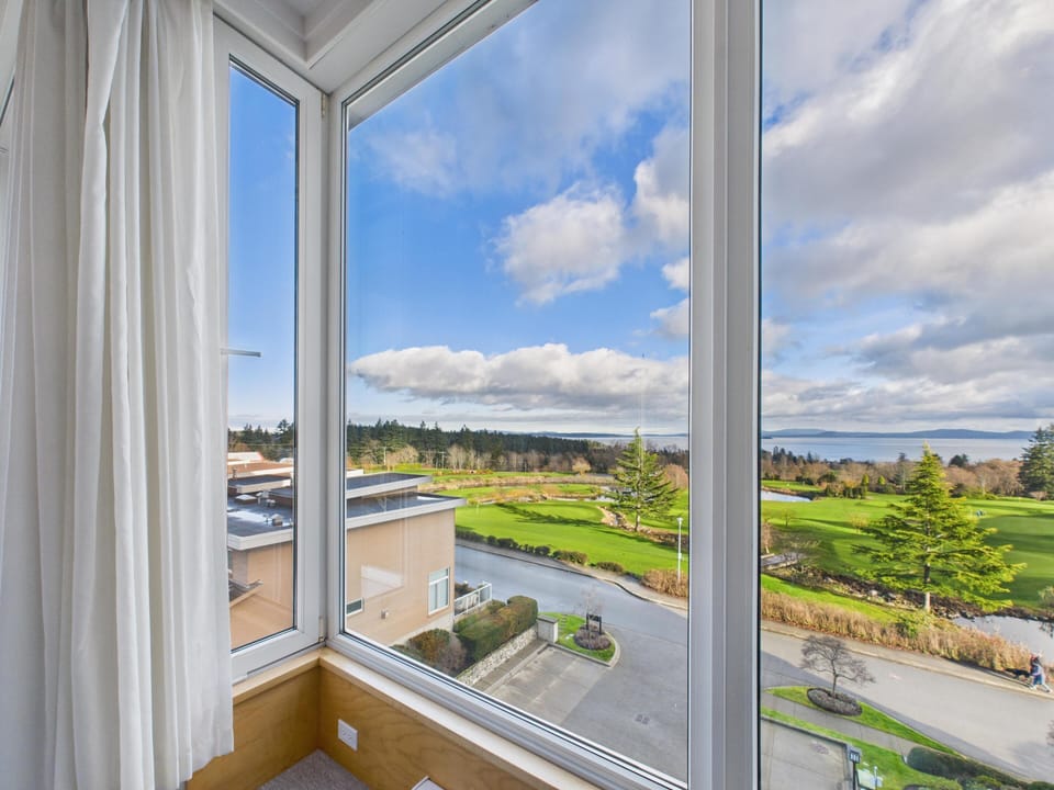 Wide corner window perspective showcasing expansive views over the neighboring golf course fairways.
