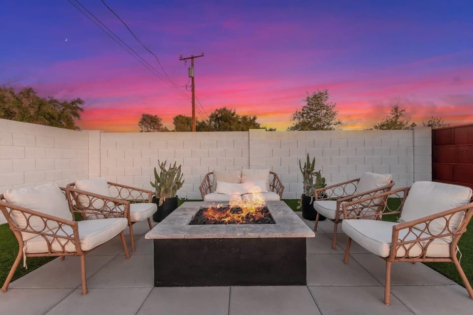 Cozy outdoor fire pit lounge with comfortable seating, perfect for relaxing evenings under a stunning Arizona sunset.