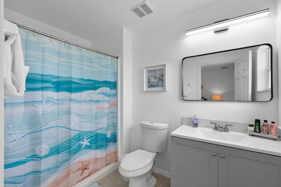 Modern bathroom with walk-in shower and fresh towels.
