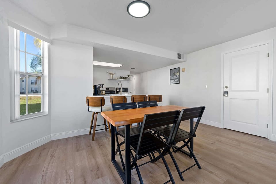 Dining area with natural light and seating for six in a modern open layout.