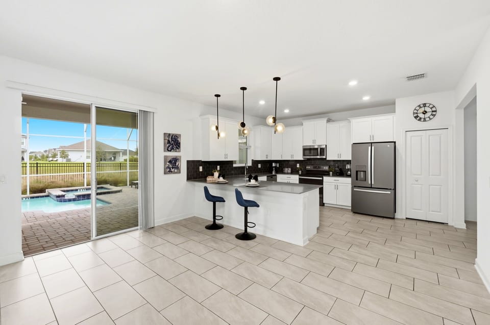 Modern kitchen with a breakfast bar and sliding doors leading to a pool area