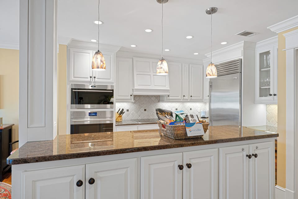 Pendant lights with warm-toned glass shades hang above the island, adding visual interest and soft ambiance