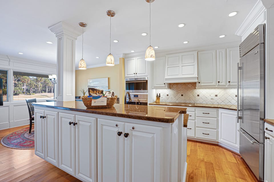 Stainless steel appliances—including a large refrigerator—add a modern, high-end touch.