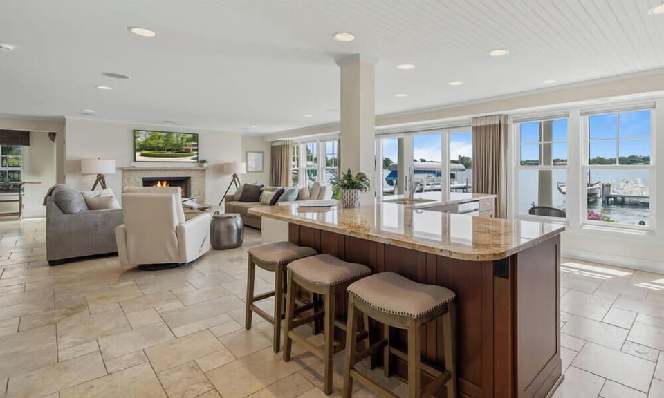 Open concept kitchen with breakfast bar seating. Living room with walk out to patio and pier.