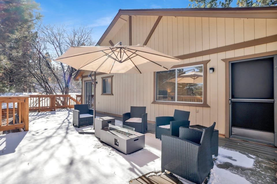 Private outdoor deck with comfortable chairs and a firepit, surrounded by tall pines, perfect for relaxing under the trees after a day of adventure—enjoy peaceful forest views, fresh air, and a truly rejuvenating stay.