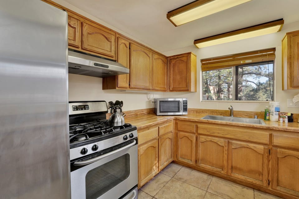 Fully equipped cabin kitchen with ample cabinetry, stove, fridge, microwave, and coffee maker—perfect for cooking meals, morning coffee, and feeling right at home on your stay.